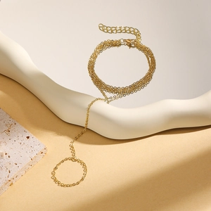 Detailed view of golden multi-layer hand chain with bow accent and turquoise pearls