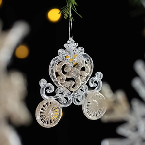 Sparkling acrylic pumpkin carriage Christmas pendant hanging on a festive pine branch