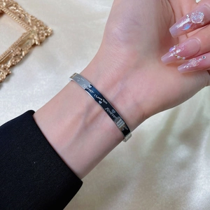 Silver stainless steel love forever engraved open cuff bracelet on satin background