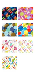 Detail showcasing cartoon birthday wrapping paper rolls with balloon and dinosaur patterns