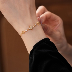 Detailed close-up of a zircon star pendant gold bracelet with adjustable pull closure