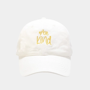 Detail of yellow 'be Kind' heart embroidery on a white cotton soft baseball cap