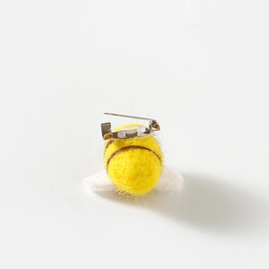 Detail view of the metal safety pin attachment on the back of a yellow wool felt bee