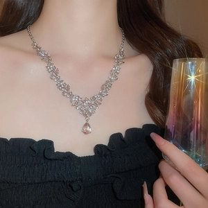Close-up of sparkling floral pendant necklace with champagne teardrop crystal on neck
