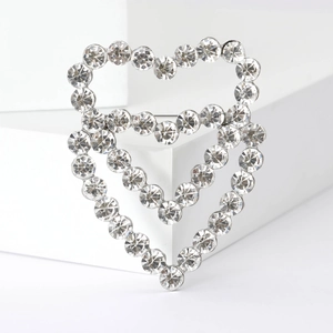 Macro shot of double heart hollow brooch with sparkling crystal rhinestones and silver finish