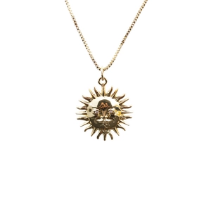 Collier minimaliste plaqué or avec pendentif soleil vintage sur fond blanc neutre