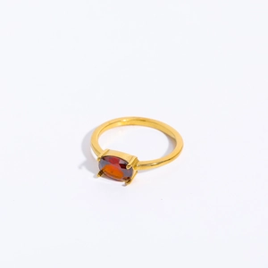 Detailed macro view of an oval orange zircon gemstone set in a sleek golden ring band