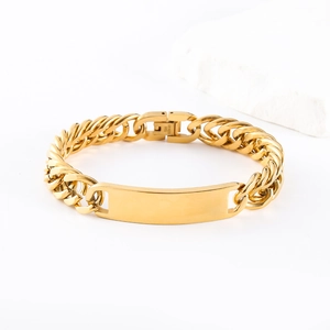 Macro detail of gold stainless steel Cuban ID bracelet with polished rectangle plate