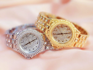 Détail de montres de luxe serties de diamants avec chiffres arabes sur soie rose