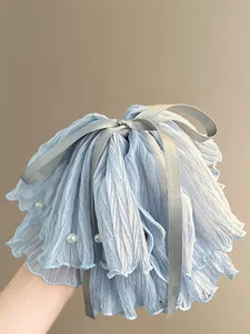 Detail of light blue pleated hair scrunchie with grey ribbon bow and pearl accents