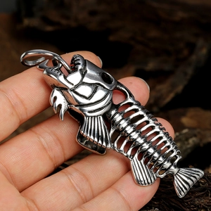 Detailed close-up of a vintage stainless steel fish bone pendant held by hand