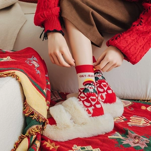 Detail of red festive crew socks featuring GET-RICH embroidery and cartoon character