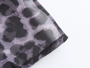 Detailed macro view of leopard print organza fabric with semi-transparent mesh texture