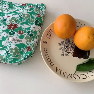 Floral cotton drawstring pouch in green with red and white patterns for makeup storage