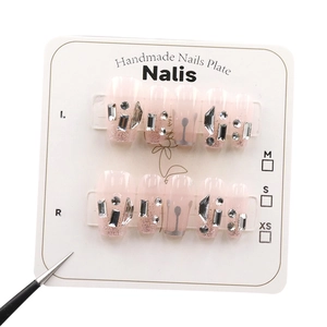 Faux ongles roses faits main avec paillettes argentées, strass et lignes sur carte blanche