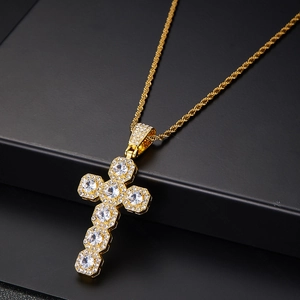Detailed view of gold cross pendant with micro-pave cubic zirconia on twisted chain