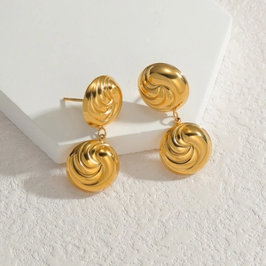 Golden double circle stud earrings with spiral texture on geometric white stand