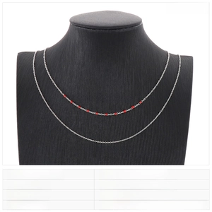 Detail of double-layer stainless steel cross chain with red resin beads on neck model