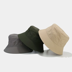 Minimalist waterproof bucket hats in grey, olive, and khaki shown in an overlapping layout