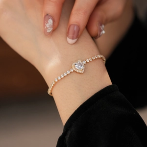 Close-up of golden heart bracelet with sparkling cubic zirconia and elegant chain detailing