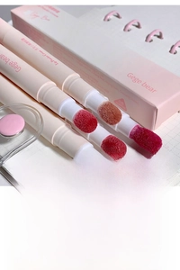 Detailed view of matte lip powder creams with sponge applicators and pink packaging