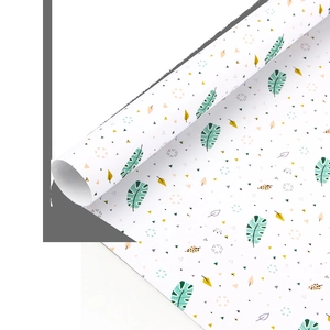 Detail of white gift wrapping paper with green tropical leaves and colorful geometric patterns