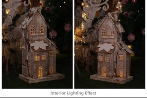 Close-up of wooden Christmas house with warm LED lights and artificial snow details