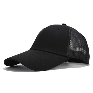 Detail view of the breathable mesh back and curved brim on this black cotton trucker hat