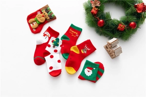 Close-up of festive Christmas socks with reindeer and Santa patterns on a white background