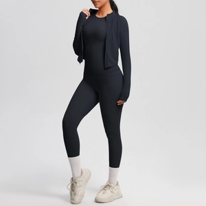 Detailed close-up of a black three-piece yoga set featuring a zip-up jacket and slim leggings