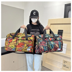 Detail of travel tote bag with colorful leaf print, double handles and front pocket