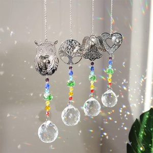 Detail of four crystal suncatchers with metal charms reflecting colorful rainbows