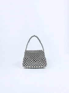 Macro detail of silver beaded handbag showing shiny metallic woven texture and geometry