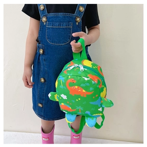 Close-up of bright green dinosaur backpack with 3D fins and vibrant cartoon patterns