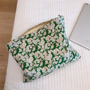 Macro detail of leaf pattern canvas pouch showing zip closure and internal storage