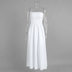 Detailed view of white cotton tube dress featuring smocked elastic bodice and pleated fabric