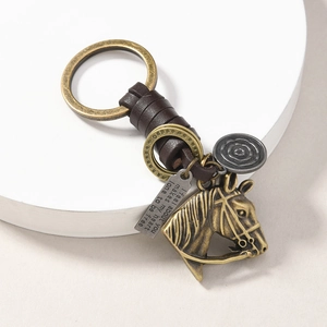 Macro detail of vintage horse head keychain with leather strap and engraved metal charm