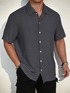 Detail shot of men's casual short sleeve shirt featuring grey seersucker textured fabric