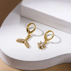 Golden fish tail and snowflake asymmetric earrings with clear cubic zirconia inlay