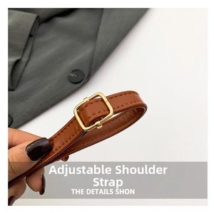 Macro detail of brown leather adjustable shoulder strap with golden buckle and stitching
