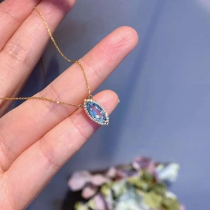 Gros plan détaillé du pendentif marquise en aigue-marine avec halo de zircons cubiques