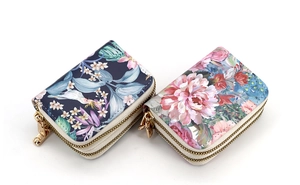 Close-up of dual-layer zipper card holders with floral patterns and leather texture