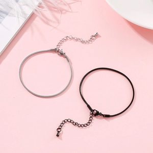Minimalist stainless steel snake bone bracelets in silver and black on pink background