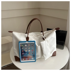 Detail of a white large capacity tote bag with brown straps and matching coin purse