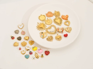 Detailed macro of assorted gold-plated DIY charms with heart, sun and insect motifs