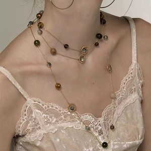 Three-layer tassels gold chain necklace with colorful faceted beads on elegant model