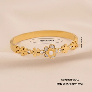 Gold stainless steel floral bangle with white enamel petals and sparkling crystals