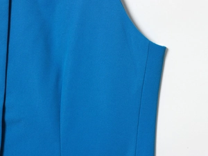 Vue détaillée du tissu en sergé bleu et des coutures de ce costume haut de gamme
