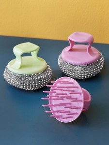 Detail of pink and green kitchen dish brushes with ergonomic handles and steel wire heads