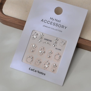 Vue détaillée des autocollants 3D pour ongles avec cadres argentés et perles blanches